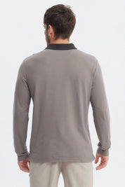 Polera gris de hombre con cuello contraste negro manga larga lisa ajuste relajado y logo pequeño en el pecho