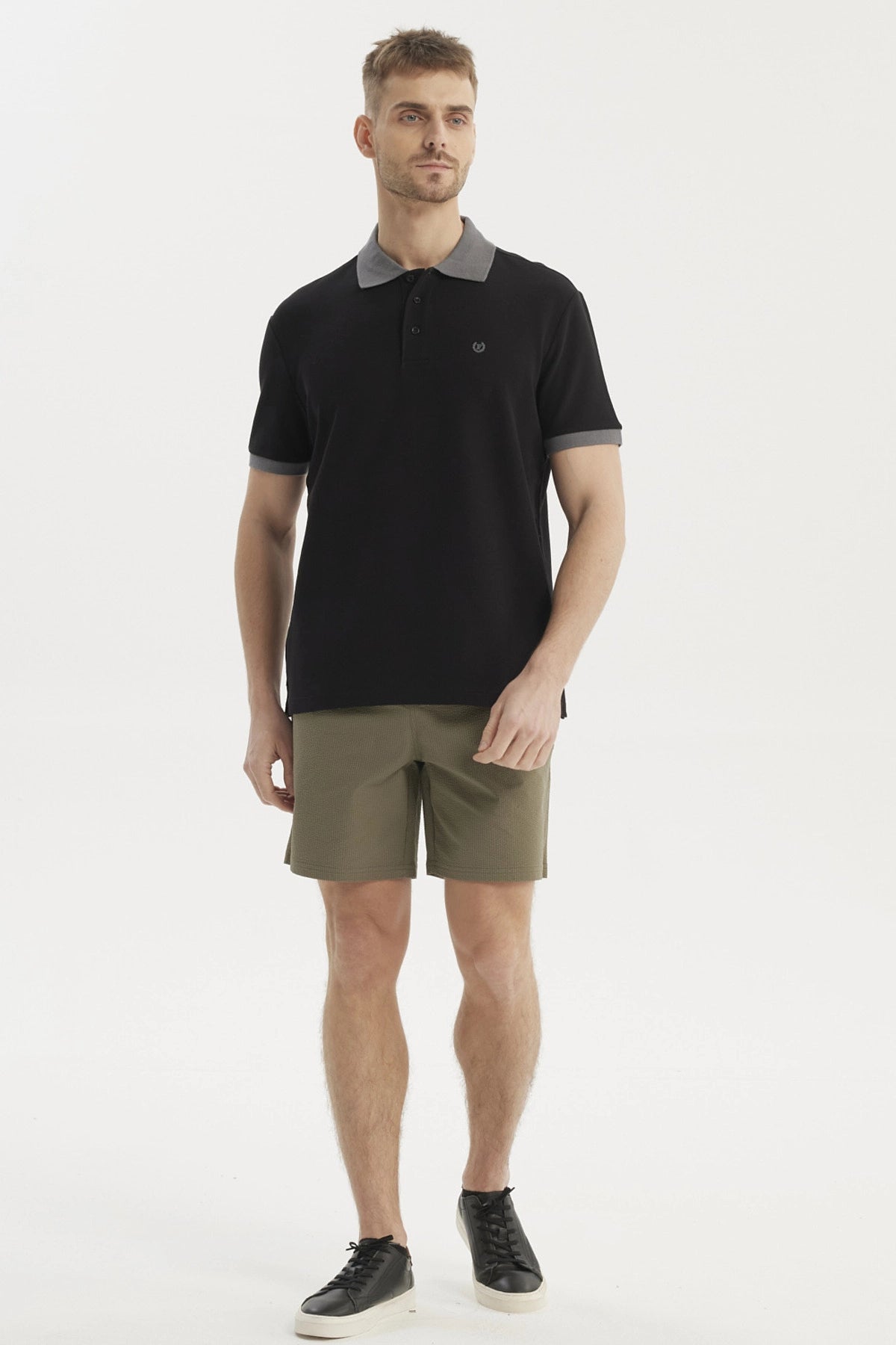 Polera negra de hombre con botones y cuello gris estilo pique sin estampa visible