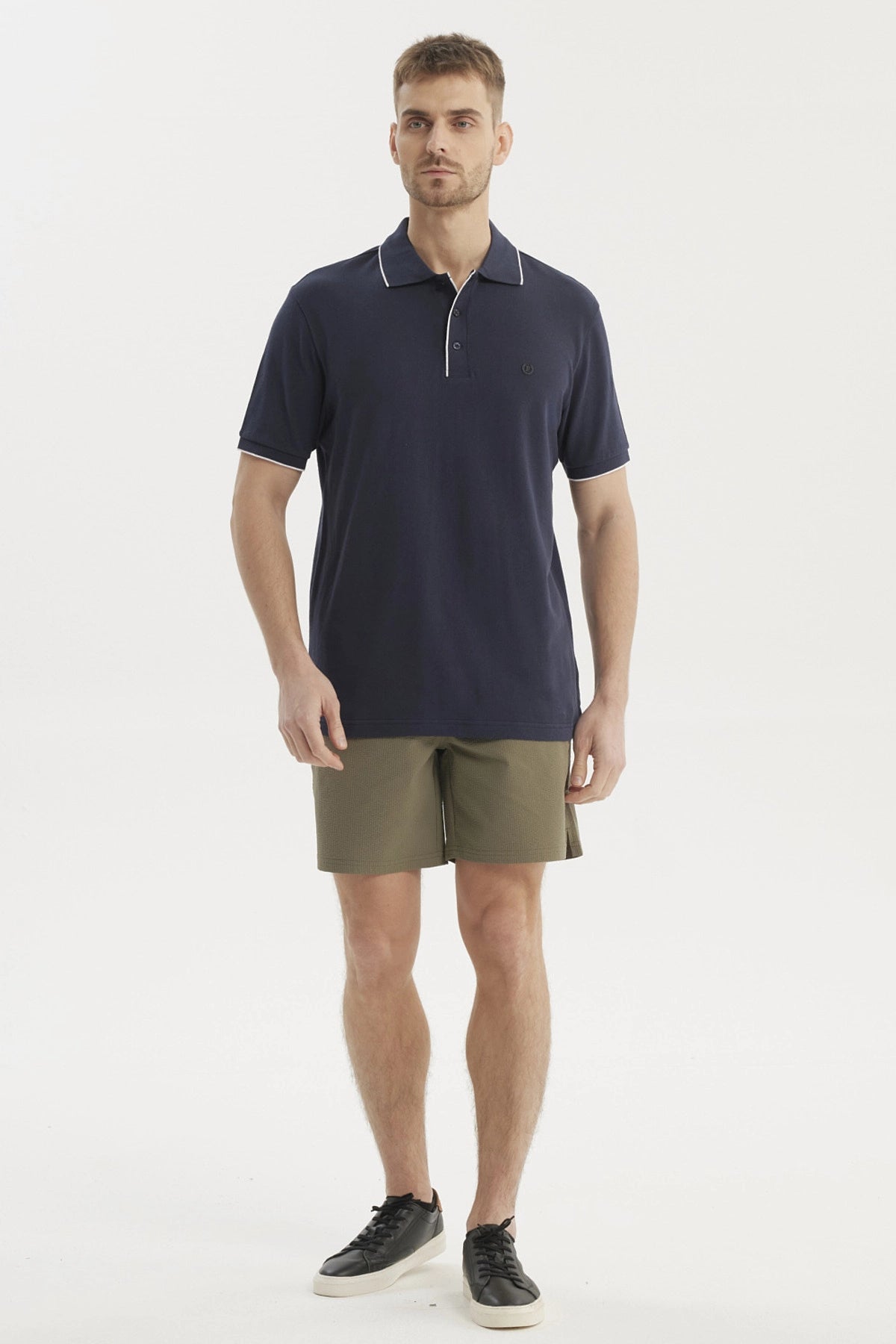 Polera hombre azul marino de algodón con cuello polo y detalle en borde blanco diseño liso elegante y versátil