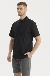 Camisa negra de hombre con cuello camisero manga corta y un bolsillo liso a la altura del pecho