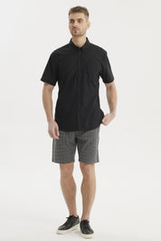 Camisa negra de hombre con cuello camisero manga corta y un bolsillo liso a la altura del pecho