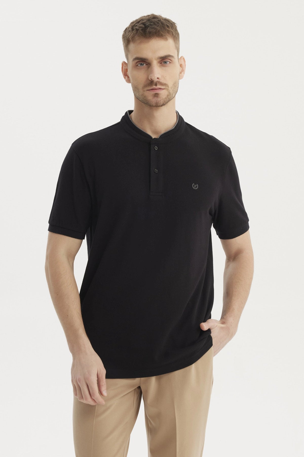 Polera negra de hombre con cuello polo y logo bordado en el pecho sin estampa visible estilo casual elegante