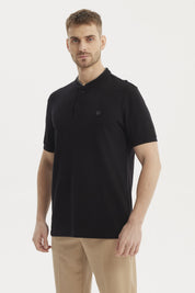 Polera negra de hombre con cuello polo y logo bordado en el pecho sin estampa visible estilo casual elegante
