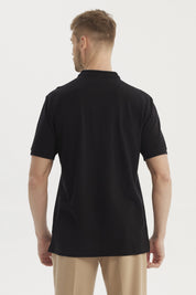 Polera negra de hombre con cuello polo y logo bordado en el pecho sin estampa visible estilo casual elegante