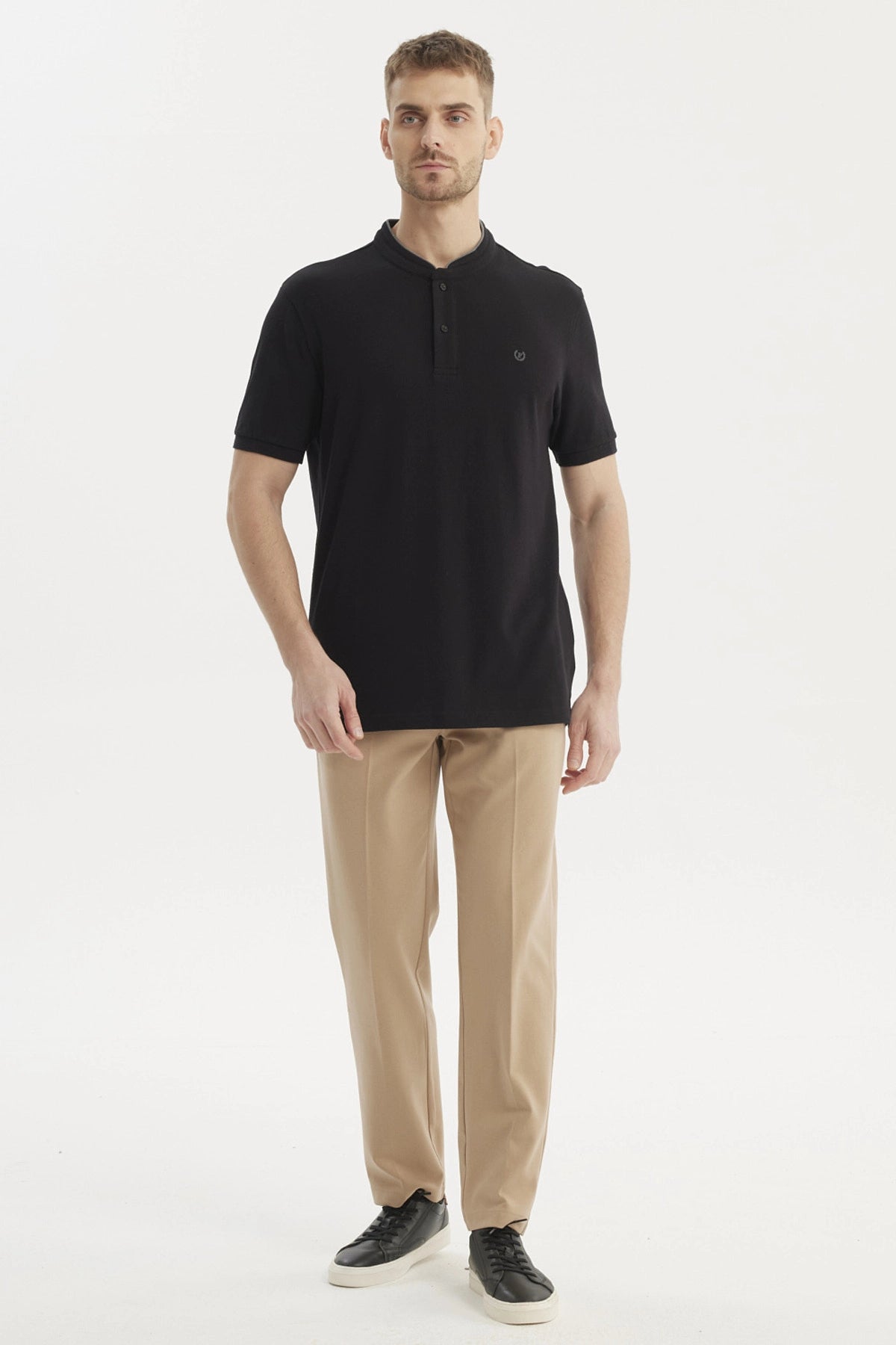 Polera negra de hombre con cuello polo y logo bordado en el pecho sin estampa visible estilo casual elegante