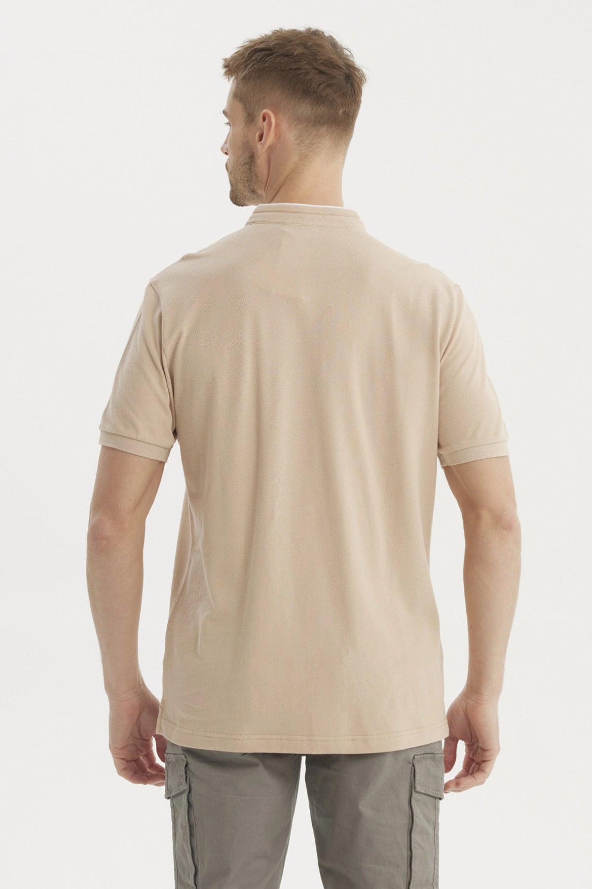 Polera hombre cuello polo beige lisa con botones y pequeño logo en el pecho estilo clásico