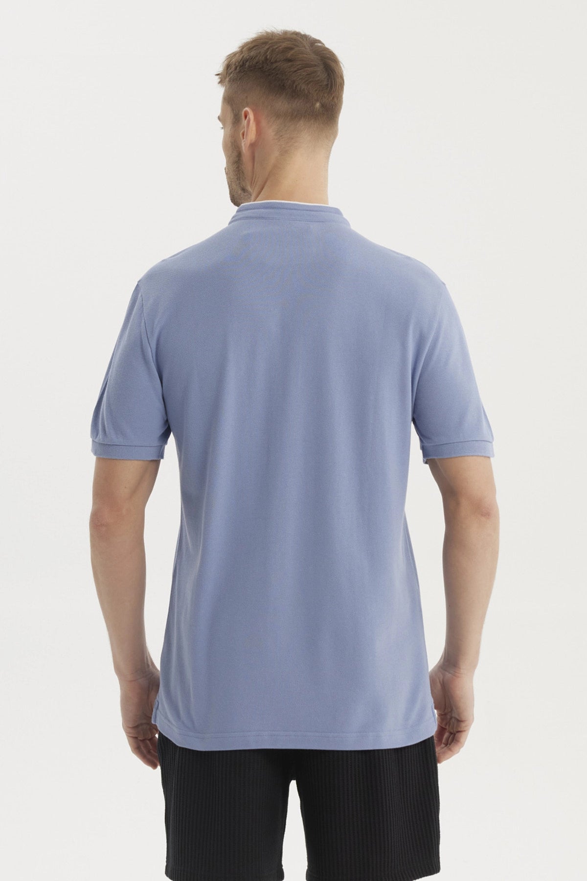 Polera azul de hombre con cuello polo y manga corta sin estampa lisa con botones al frente y pequeño logo bordado