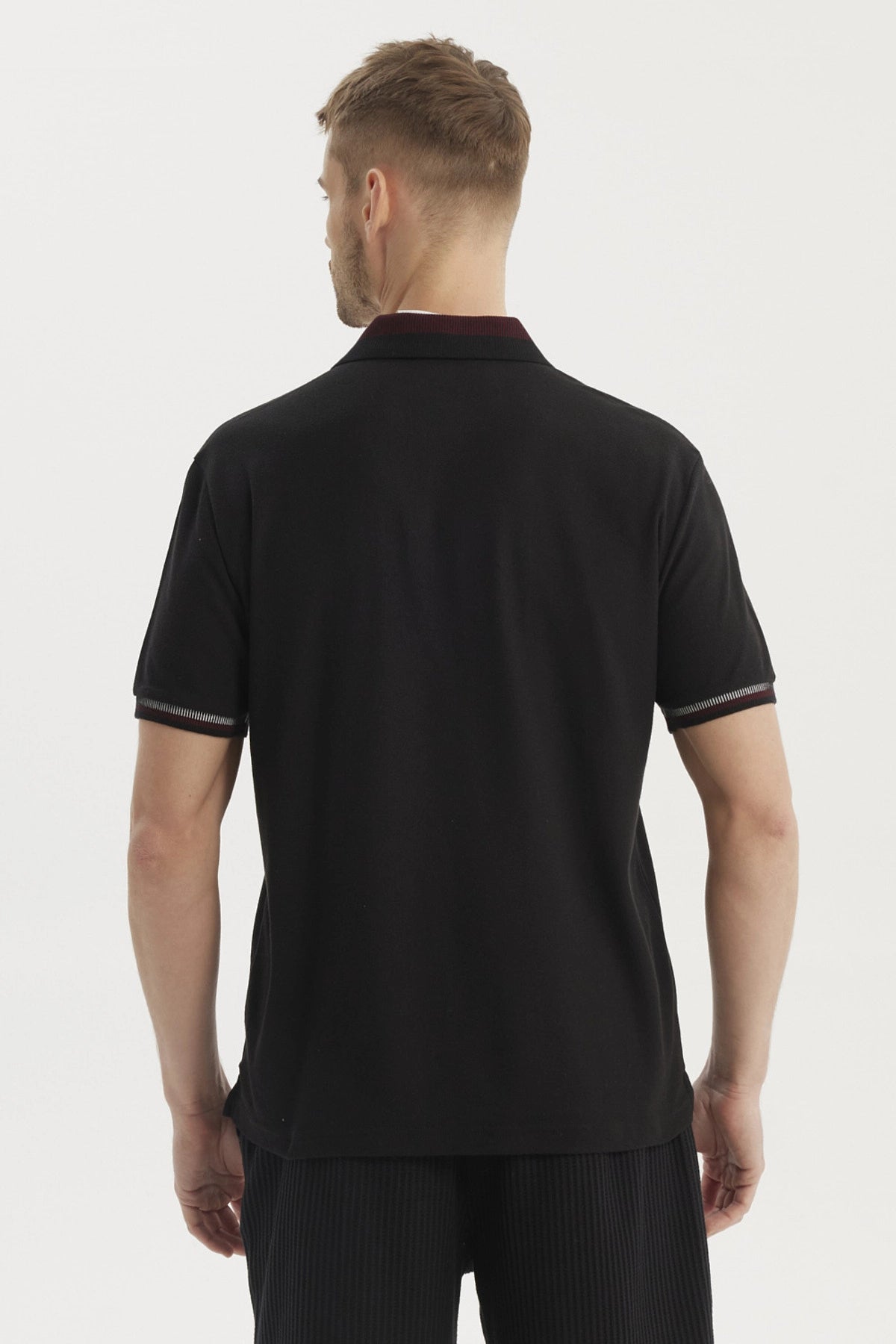 Polera polo negra para hombre con cuello contrastante detalle bordado en el pecho estilo casual y elegante sin estampa
