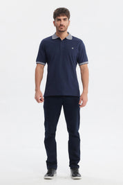 Polera slim azul marino con cuello camisero gris y logo bordado pequeño en el pecho sin estampa lisa y elegante