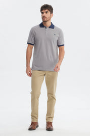 Polera hombre slim gris con cuello camisero azul marino y logo pequeño en el pecho