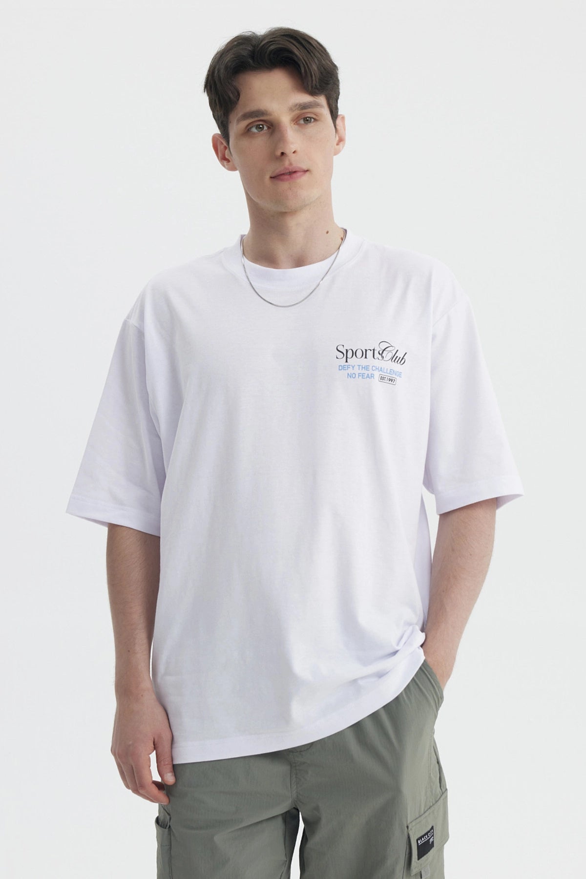 Polera oversize blanca con texto Sport Club en el pecho estilo casual sin estampa adicional