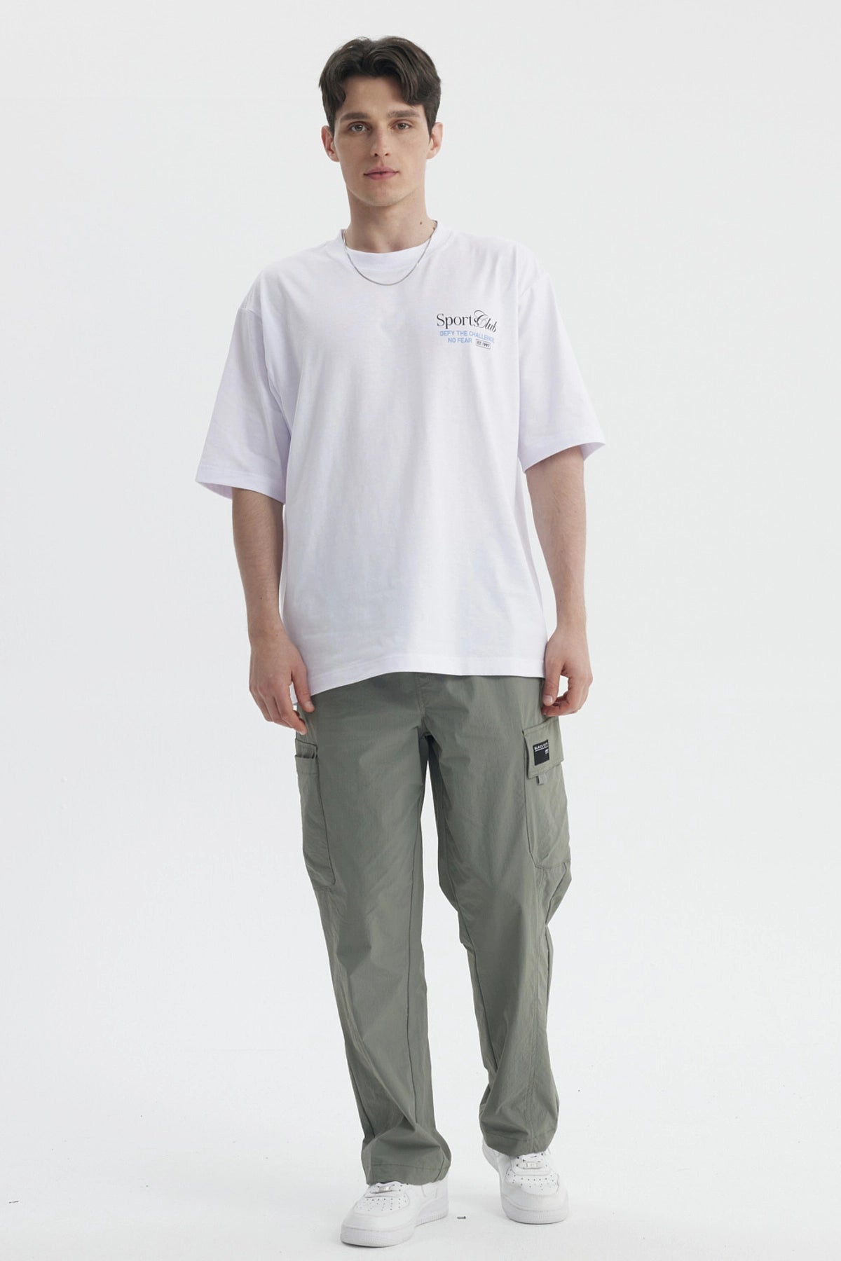 Polera oversize blanca con texto Sport Club en el pecho estilo casual sin estampa adicional