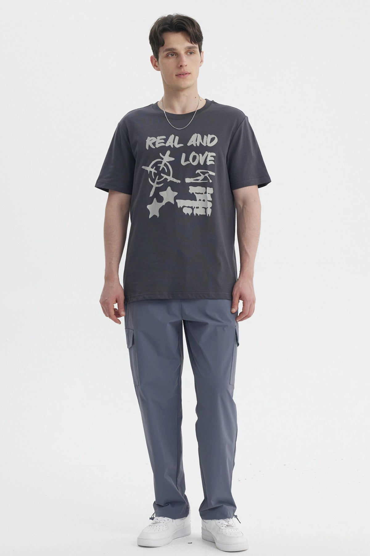 Polera oversize marengo con estampa grande al frente con texto Real And Love y símbolos abstractos en blanco