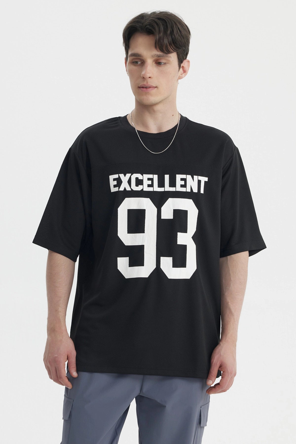 Polera oversize negra con texto Excellent 93 en el pecho estilo deportivo gráfico grande en blanco