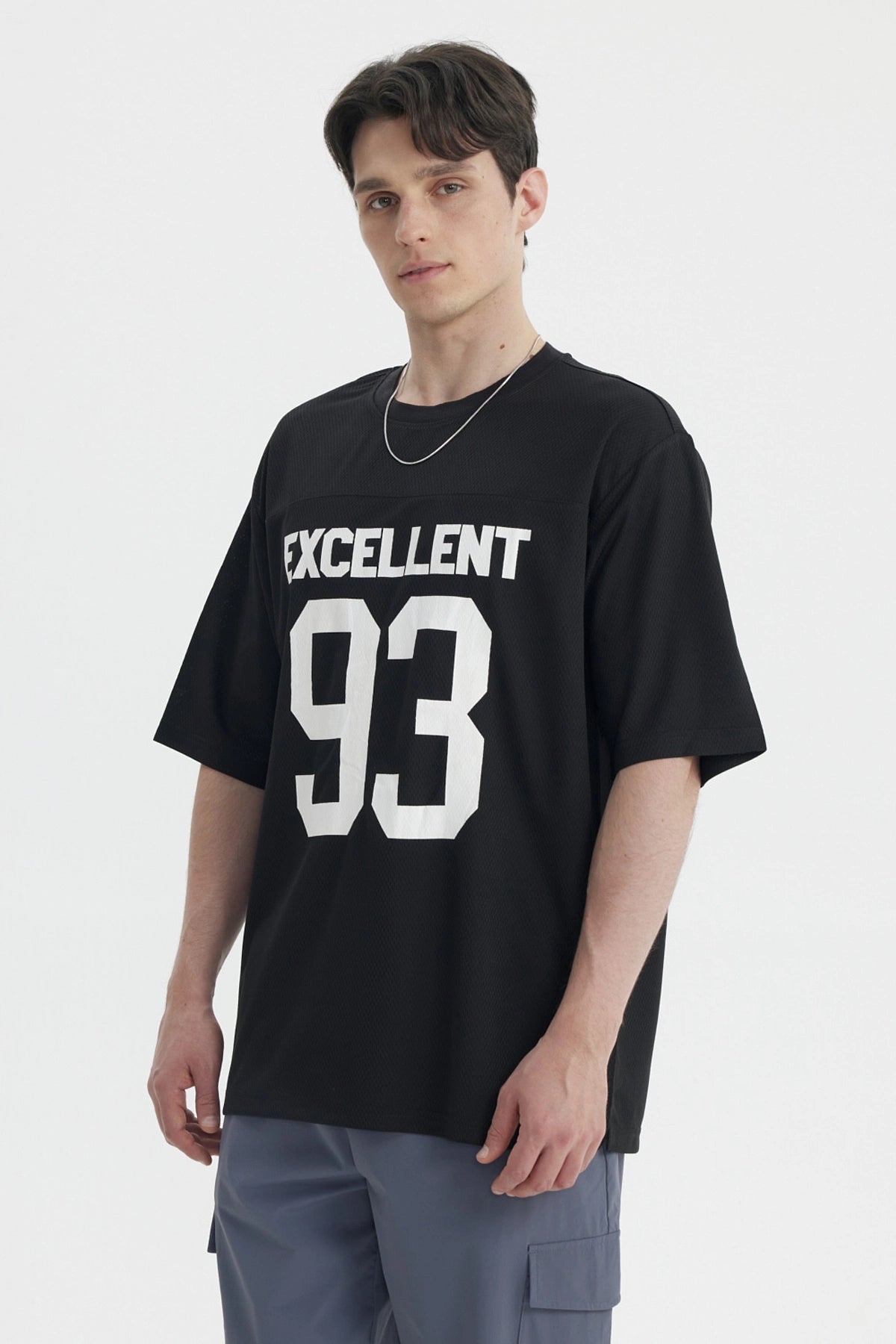 Polera oversize negra con texto Excellent 93 en el pecho estilo deportivo gráfico grande en blanco