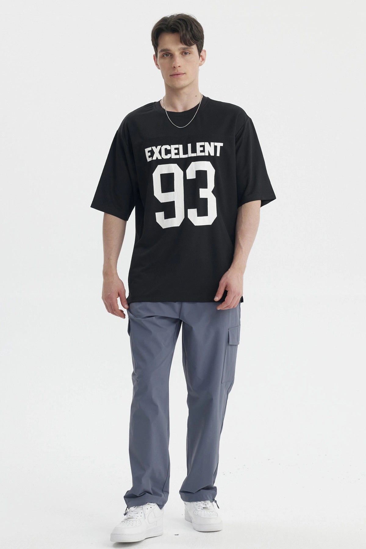 Polera oversize negra con texto Excellent 93 en el pecho estilo deportivo gráfico grande en blanco