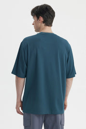Polera oversize petróleo con texto BRAVE 7 en blanco centrado al frente estilo deportivo y casual