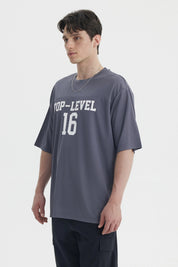 Polera oversize gris de hombre con texto Top-Level 16 en el pecho estilo deportivo casual sin estampa adicional