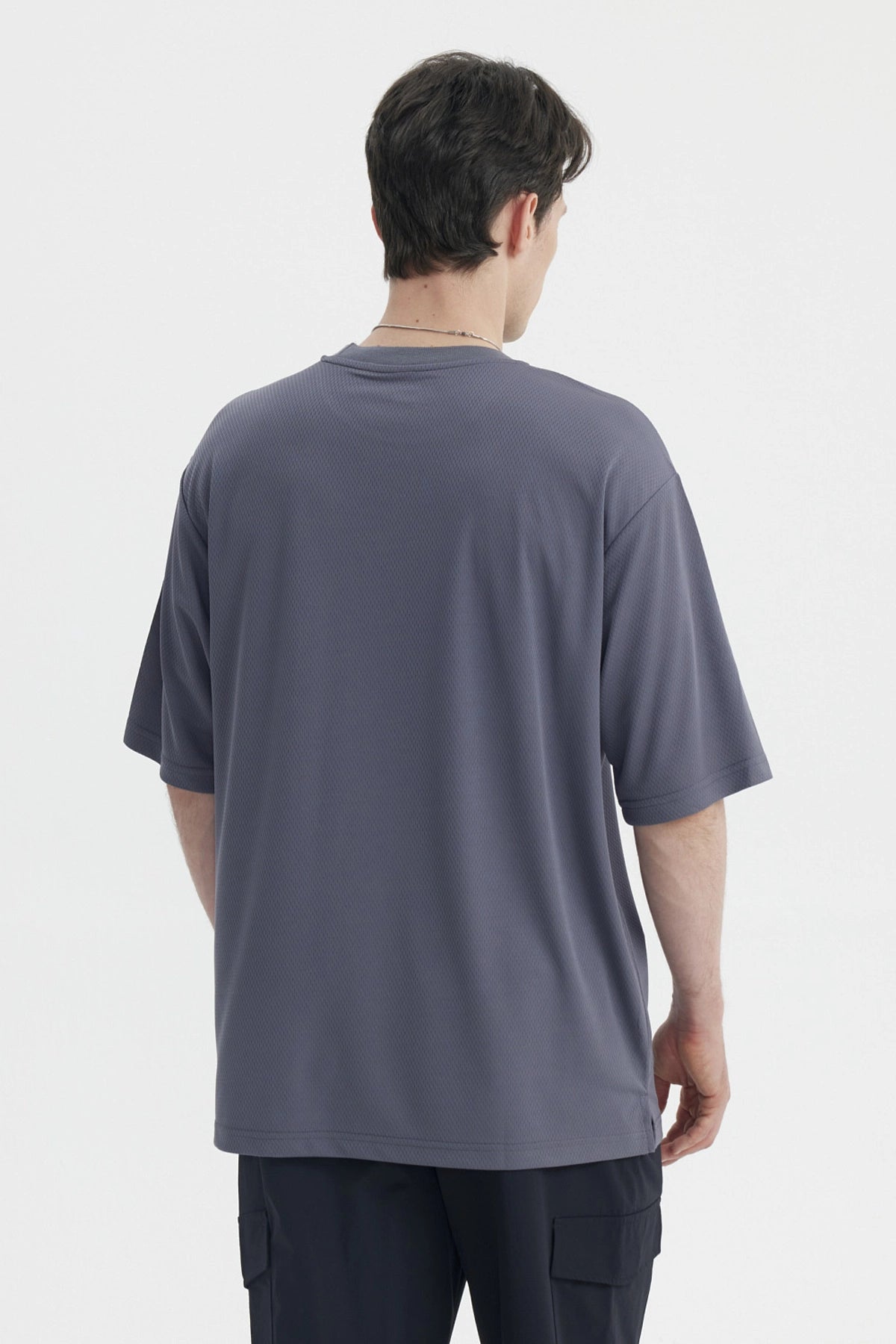 Polera oversize gris de hombre con texto Top-Level 16 en el pecho estilo deportivo casual sin estampa adicional