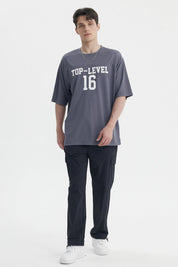 Polera oversize gris de hombre con texto Top-Level 16 en el pecho estilo deportivo casual sin estampa adicional