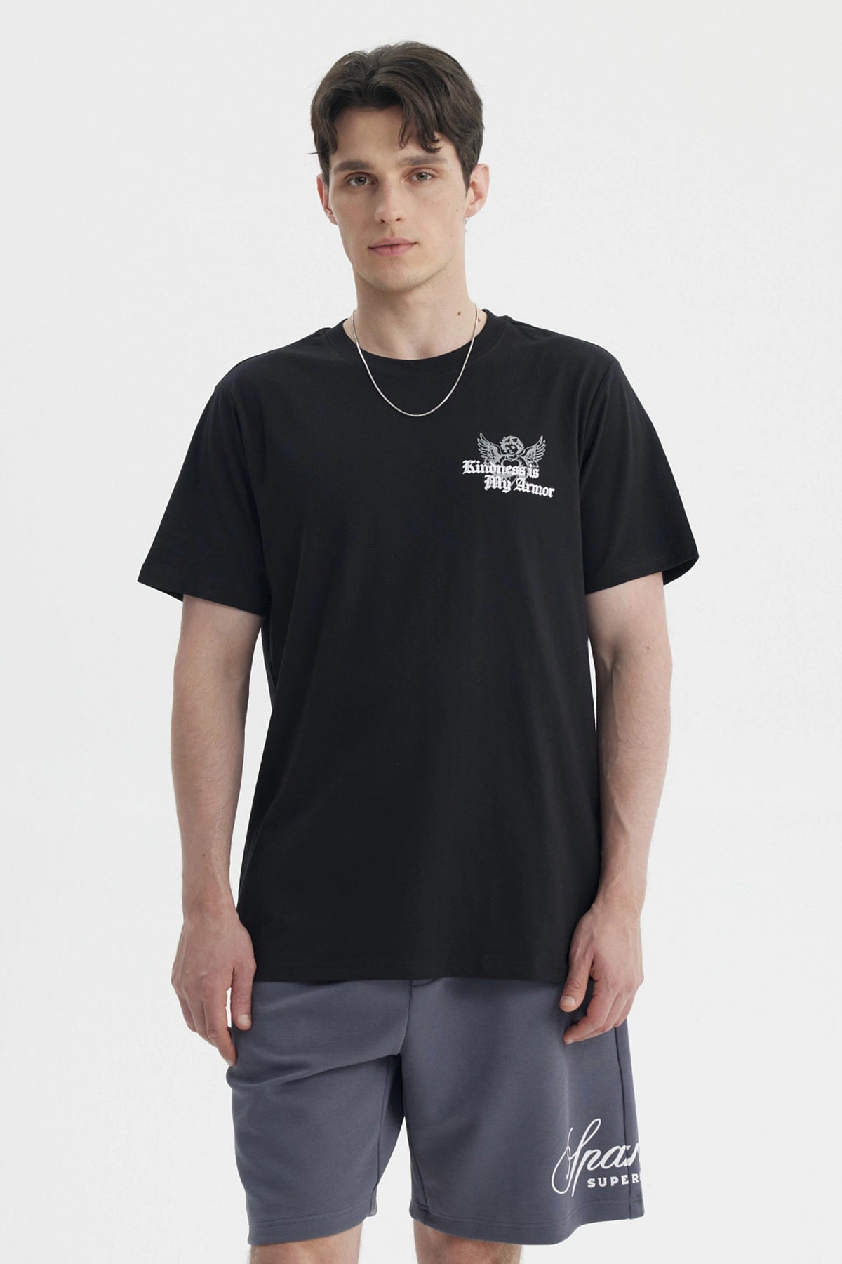 Polera negra slim para hombre con diseño gráfico blanco en el pecho que dice Kindness is My Armor