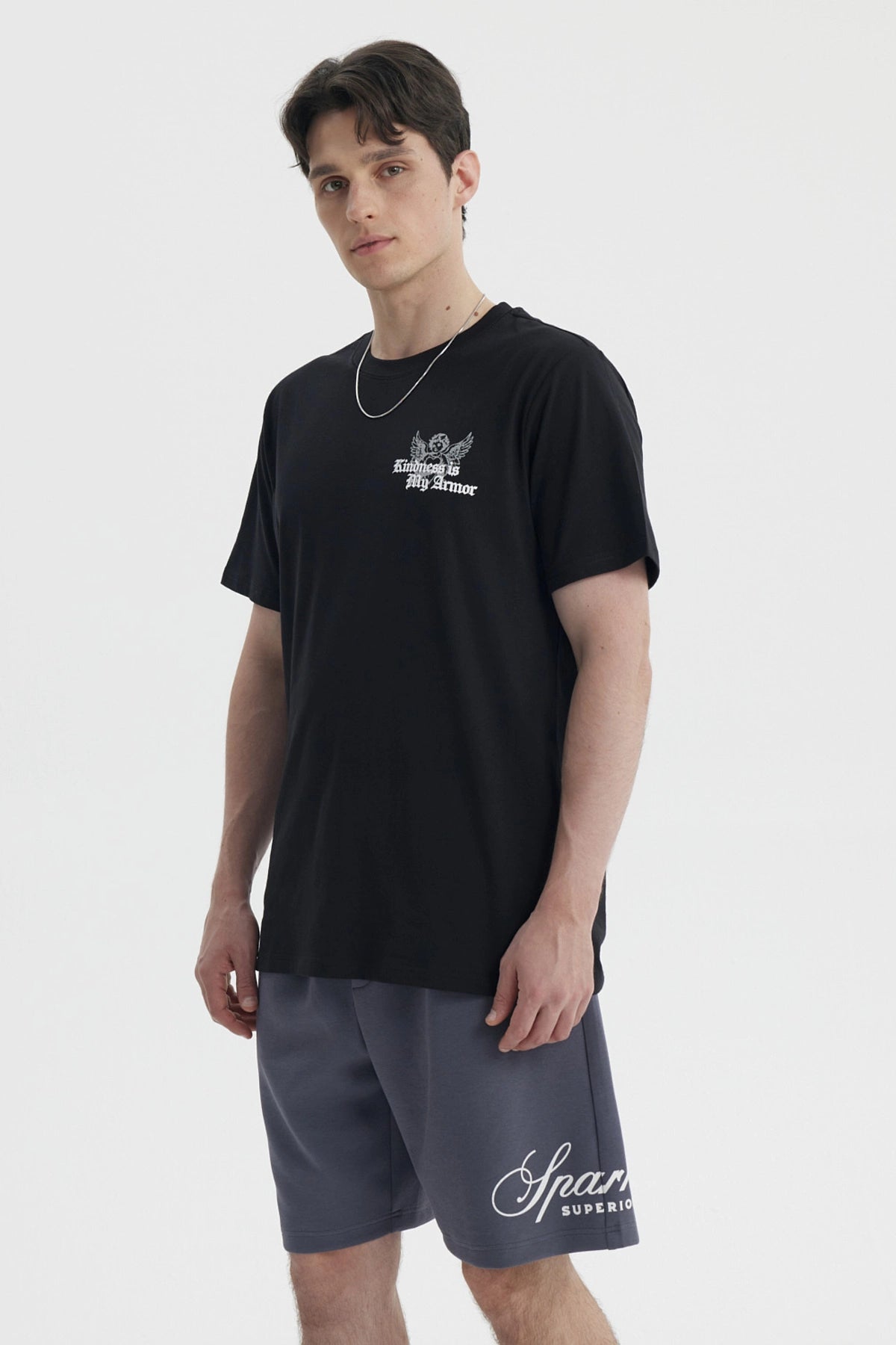 Polera negra slim para hombre con diseño gráfico blanco en el pecho que dice Kindness is My Armor