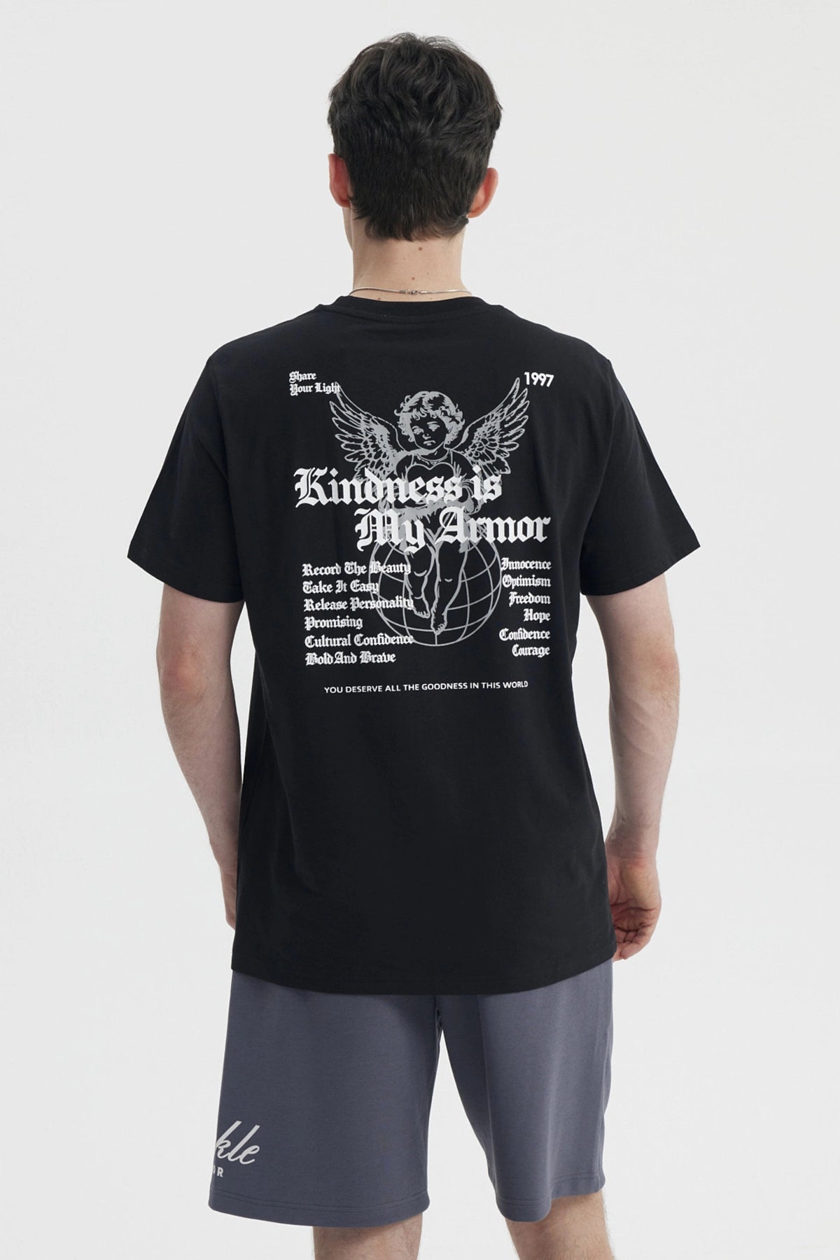 Polera negra slim para hombre con diseño gráfico blanco en el pecho que dice Kindness is My Armor