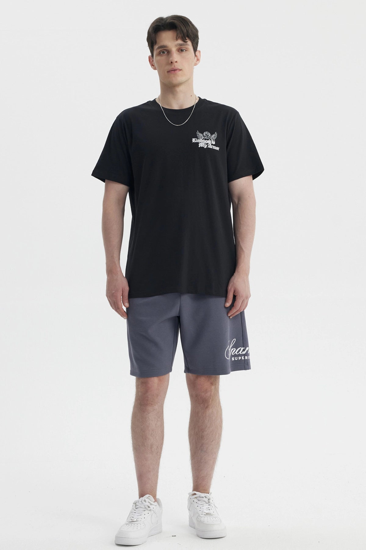 Polera negra slim para hombre con diseño gráfico blanco en el pecho que dice Kindness is My Armor