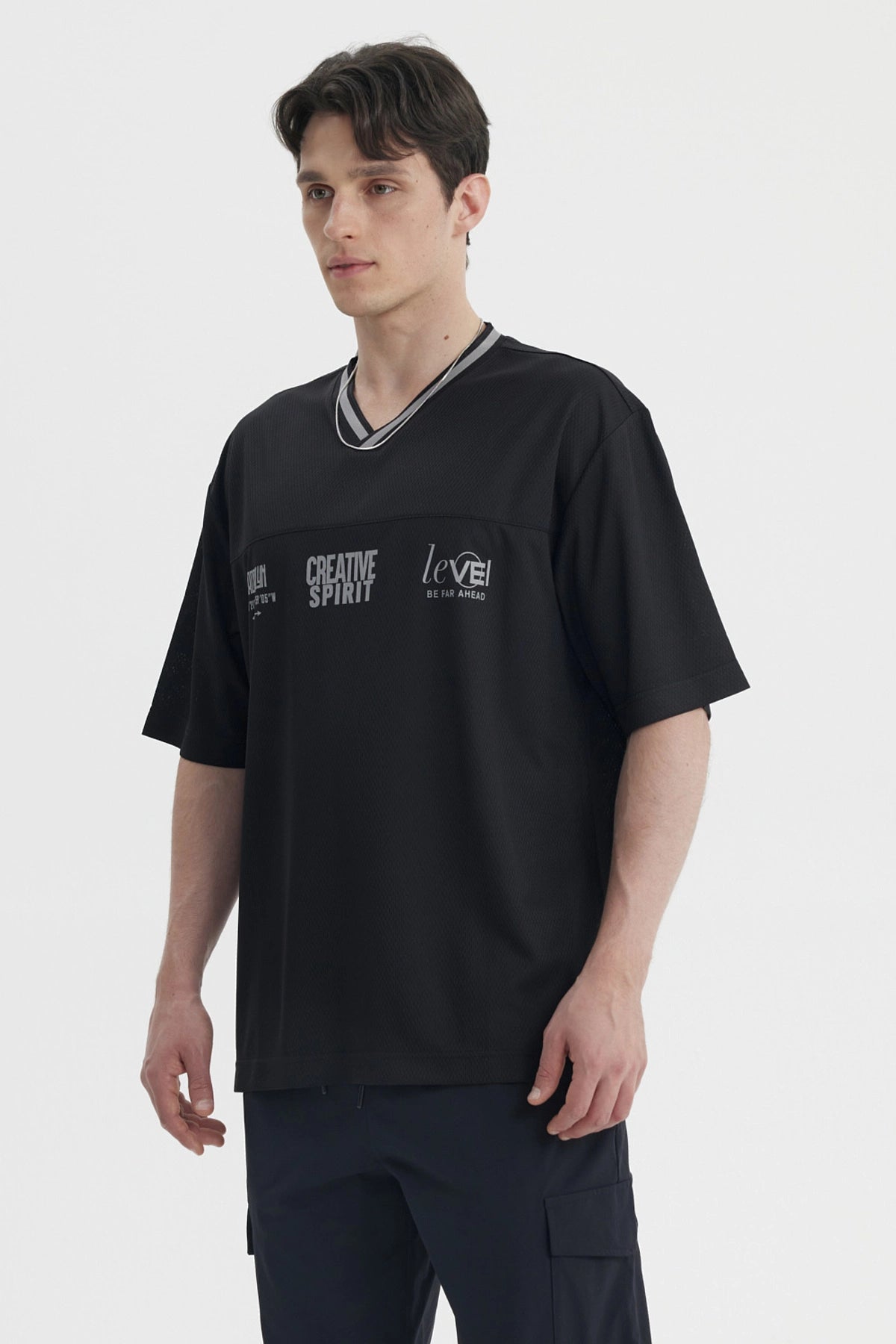 Polera hombre negra de corte slim con cuello en V y texto creativo en el pecho estilo casual moderno