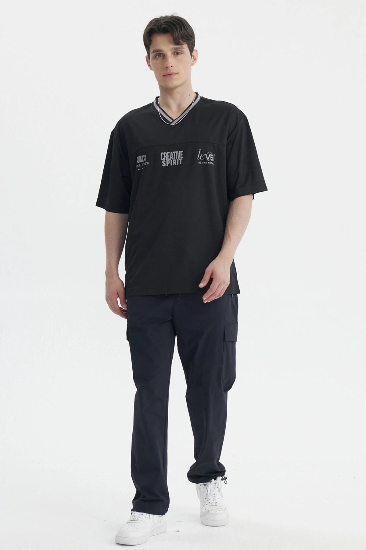 Polera hombre negra de corte slim con cuello en V y texto creativo en el pecho estilo casual moderno