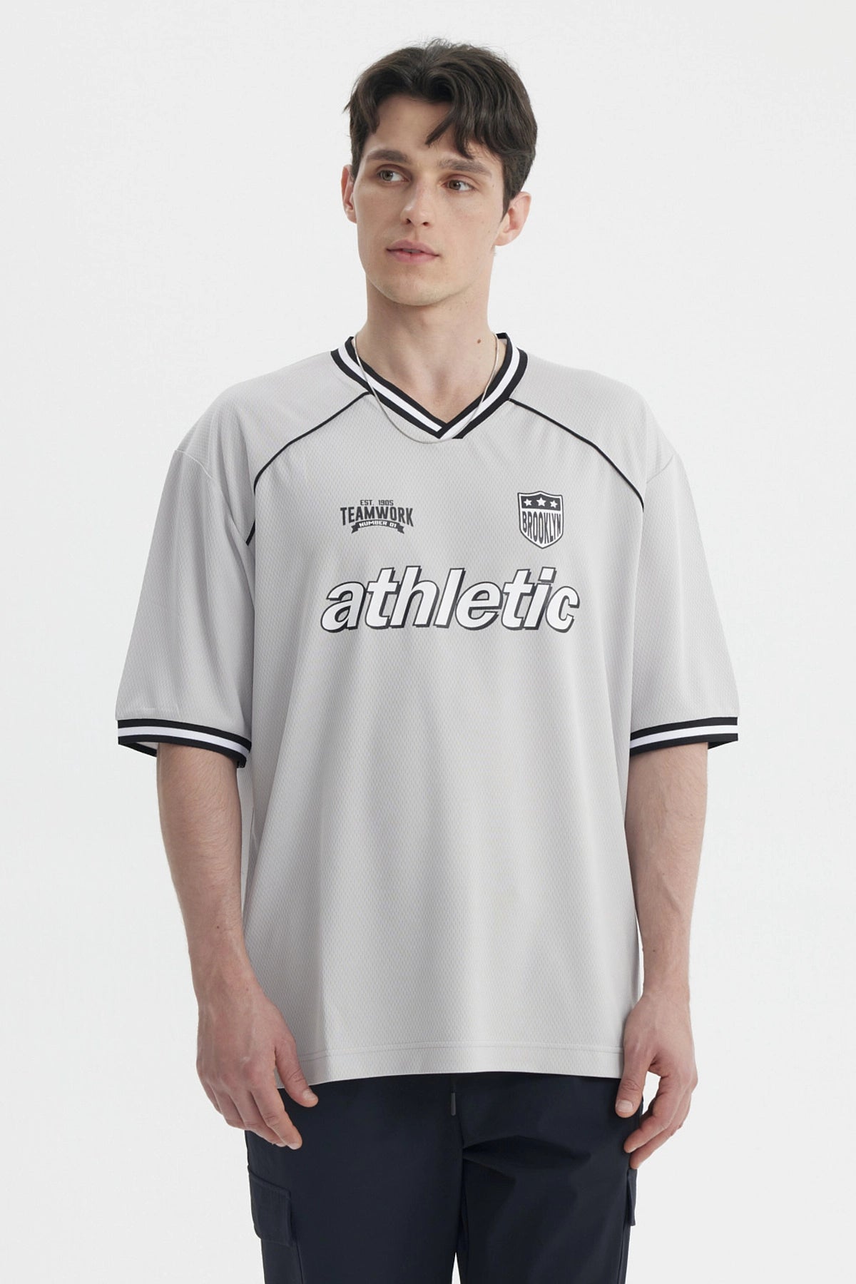 Polera gris marengo de hombre estilo slim con cuello en V y detalles en negro sin estampa visible lisa y moderna