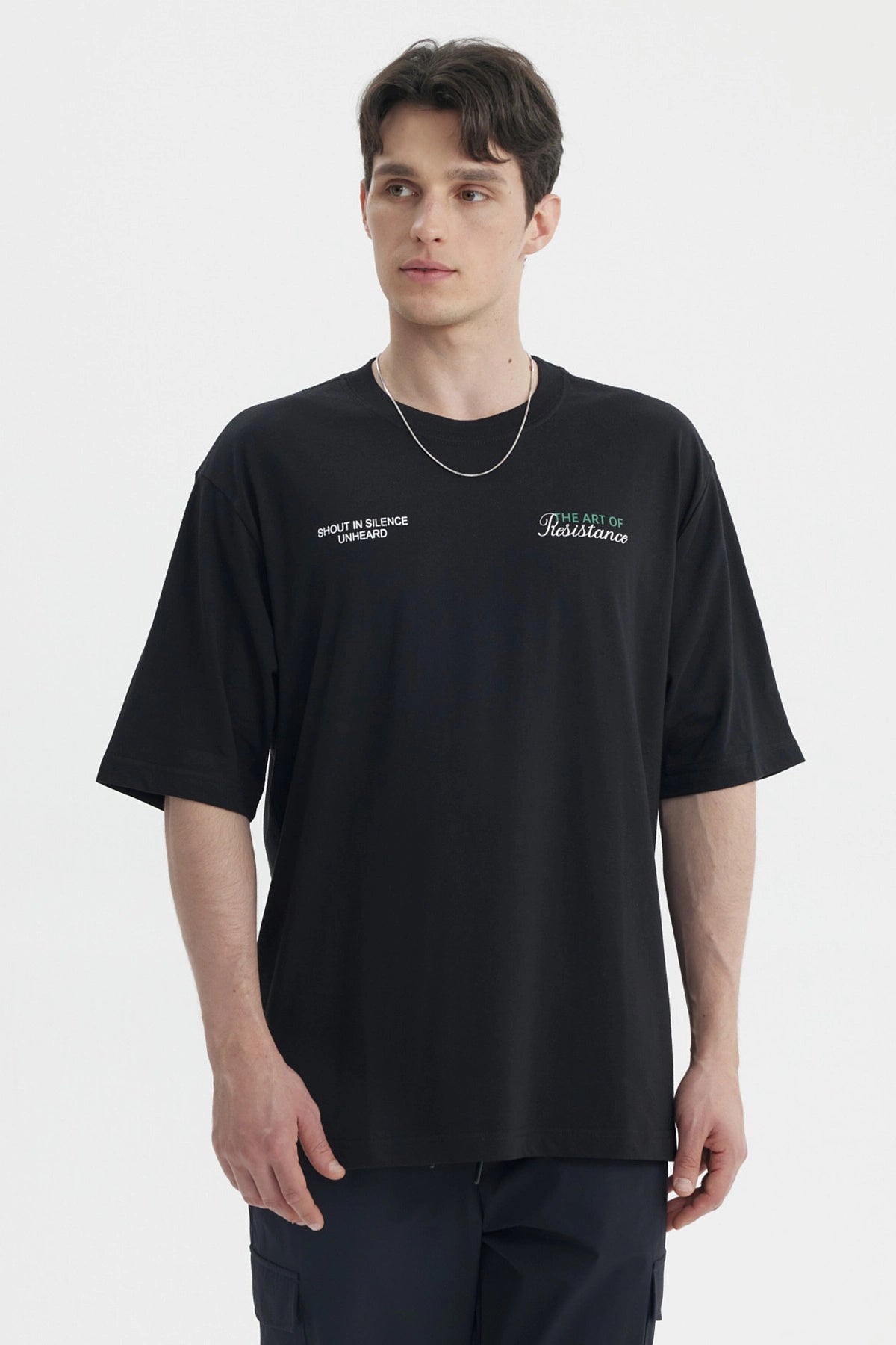 Polera oversize negra para hombre con texto blanco en el pecho estilo casual moderno