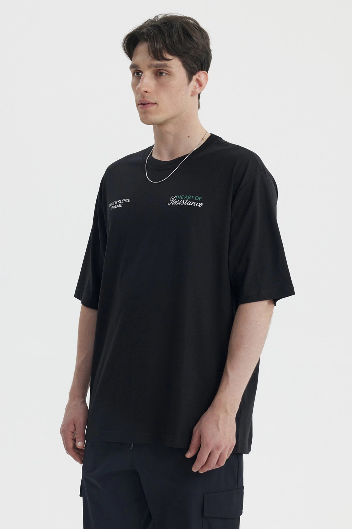 Polera oversize negra para hombre con texto blanco en el pecho estilo casual moderno