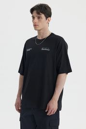 Polera oversize negra para hombre con texto blanco en el pecho estilo casual moderno