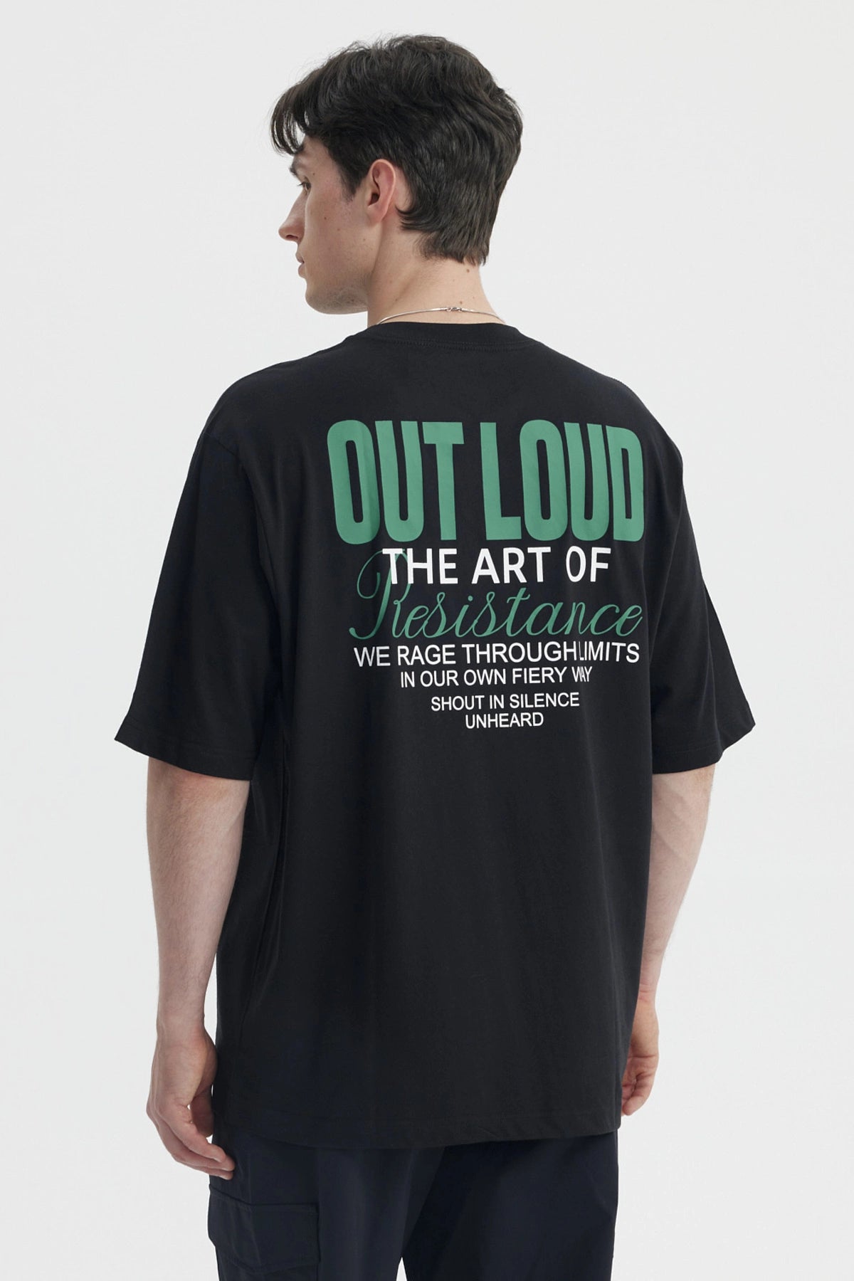 Polera oversize negra para hombre con texto blanco en el pecho estilo casual moderno