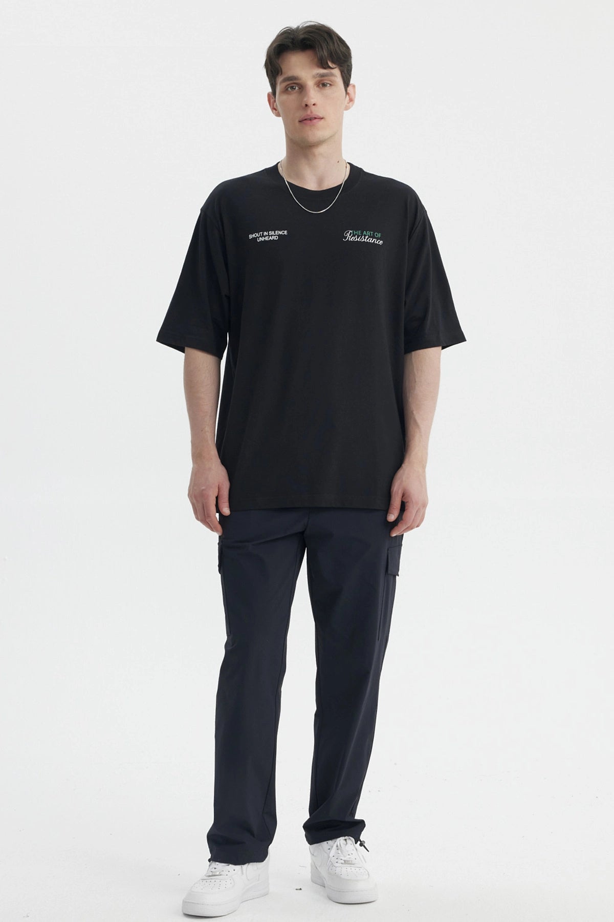 Polera oversize negra para hombre con texto blanco en el pecho estilo casual moderno