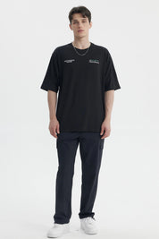 Polera oversize negra para hombre con texto blanco en el pecho estilo casual moderno
