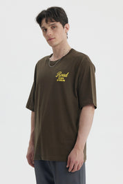 Polera oversize verde militar con estampado amarillo en el pecho que dice Road No Maps No Problems estilo casual relajado