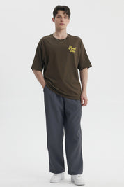 Polera oversize verde militar con estampado amarillo en el pecho que dice Road No Maps No Problems estilo casual relajado