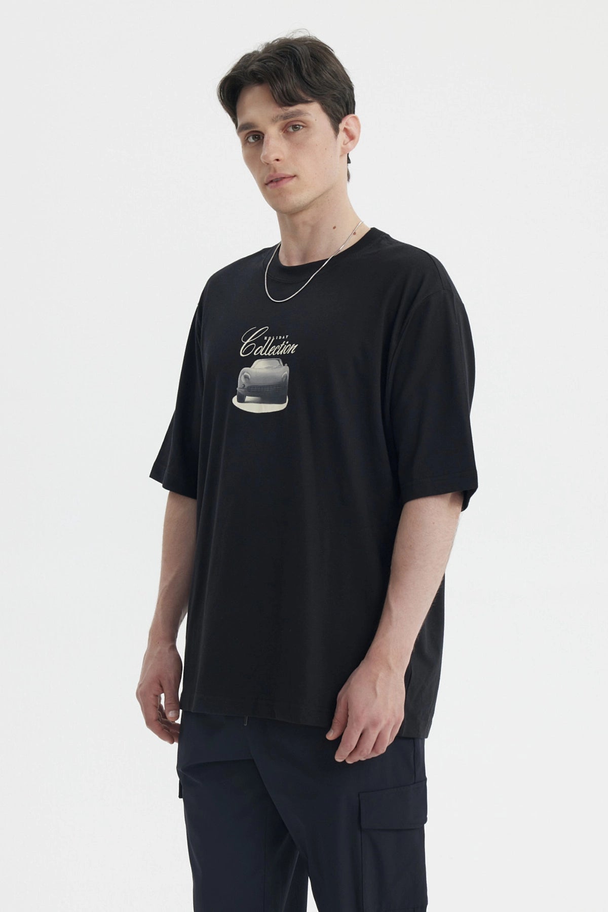 Polera negra slim para hombre con estampa central de auto clásico y texto Friday Collection en estilo retro