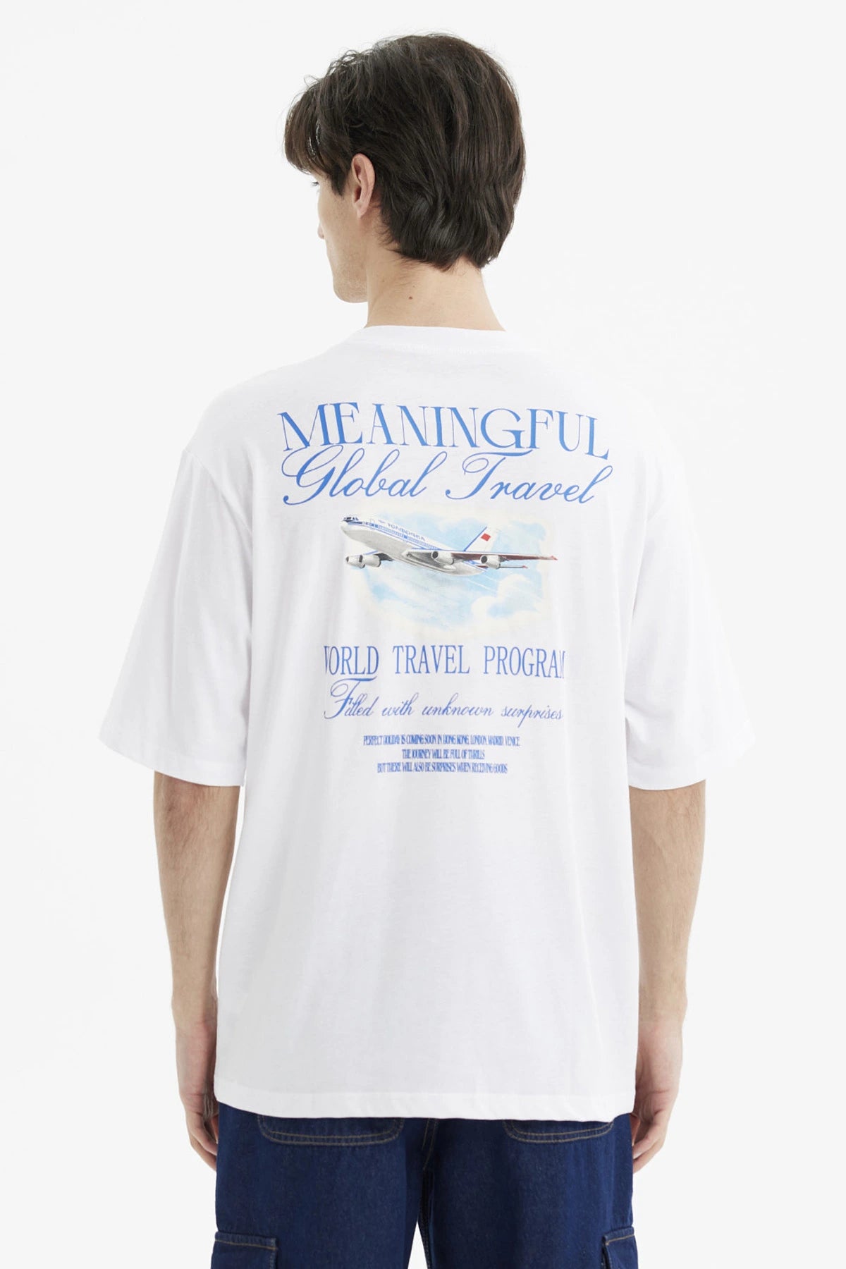 Polera hombre slim blanca con texto azul Meaningful Global Travel en el pecho estilo minimalista urbana y cómoda