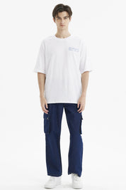 Polera hombre slim blanca con texto azul Meaningful Global Travel en el pecho estilo minimalista urbana y cómoda