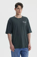 Polera hombre slim verde con estampa pequeña en el pecho que dice Perfect holiday Global travel en blanco casual y cómoda