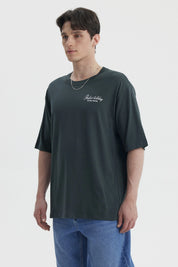 Polera hombre slim verde con estampa pequeña en el pecho que dice Perfect holiday Global travel en blanco casual y cómoda