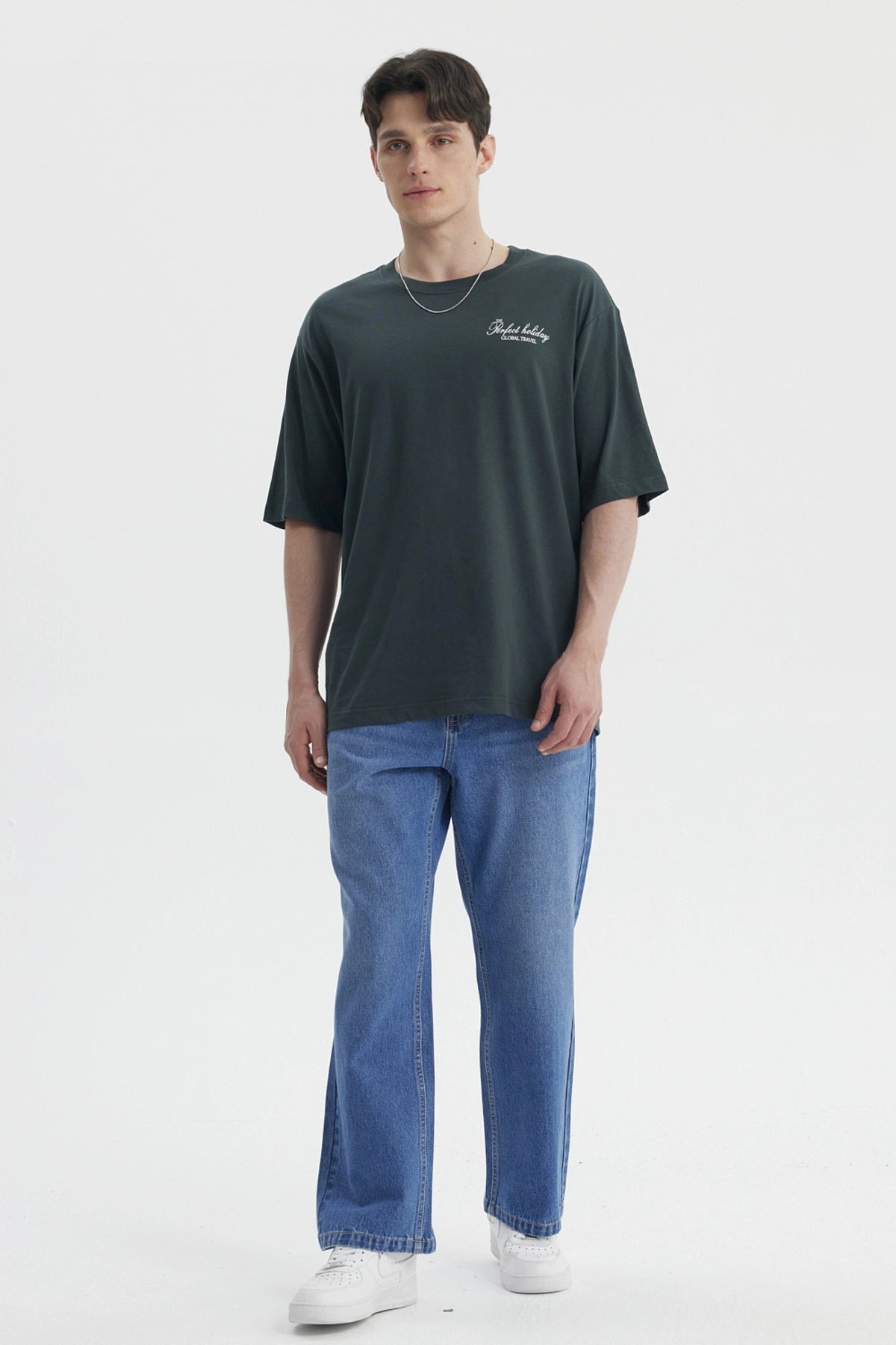 Polera hombre slim verde con estampa pequeña en el pecho que dice Perfect holiday Global travel en blanco casual y cómoda