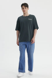 Polera hombre slim verde con estampa pequeña en el pecho que dice Perfect holiday Global travel en blanco casual y cómoda
