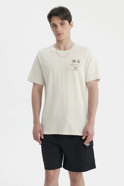 Polera oversize beige para hombre con estampado gráfico pequeño en el pecho a la izquierda