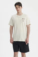 Polera oversize beige para hombre con estampado gráfico pequeño en el pecho a la izquierda