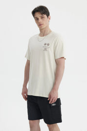 Polera oversize beige para hombre con estampado gráfico pequeño en el pecho a la izquierda