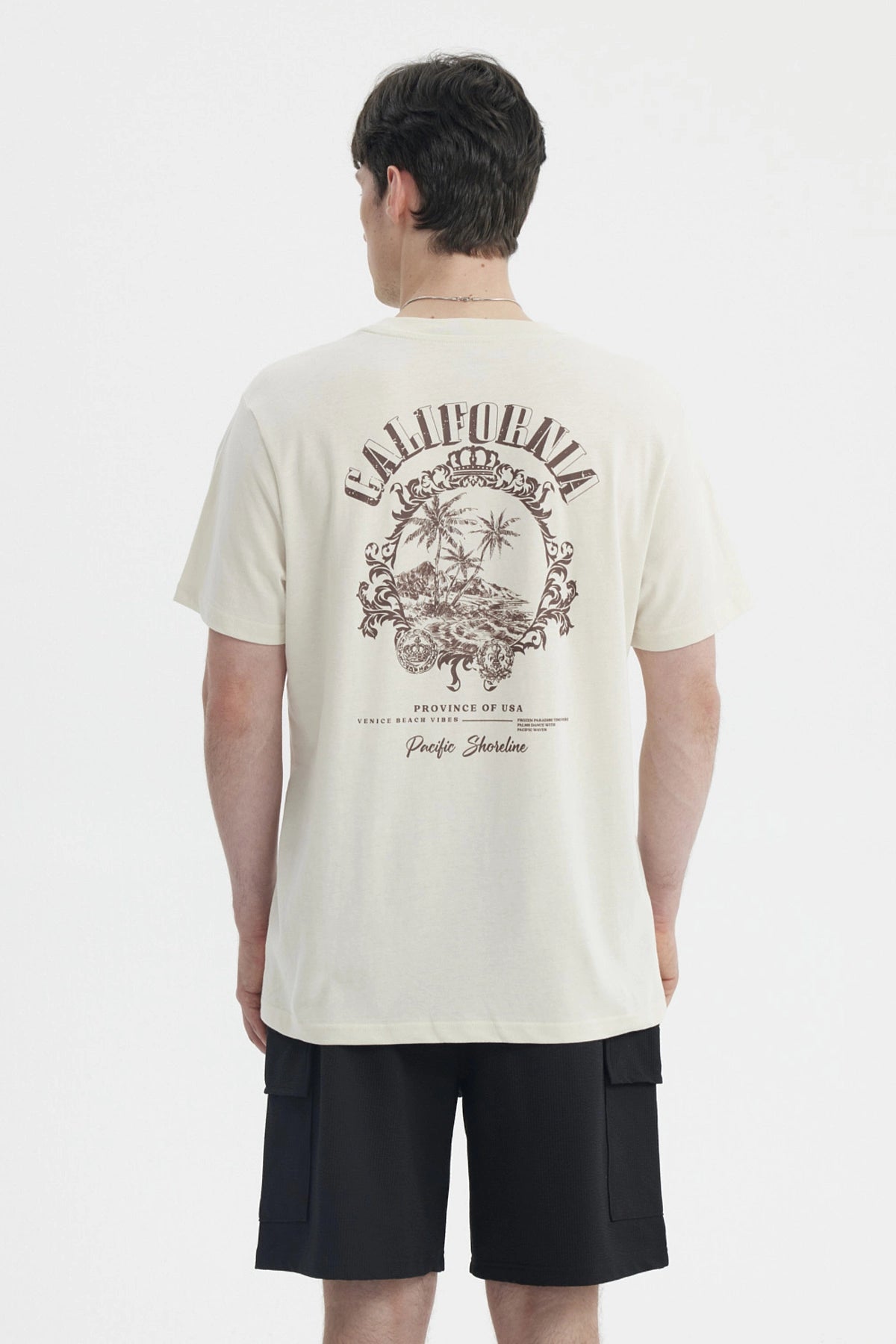 Polera oversize beige para hombre con estampado gráfico pequeño en el pecho a la izquierda